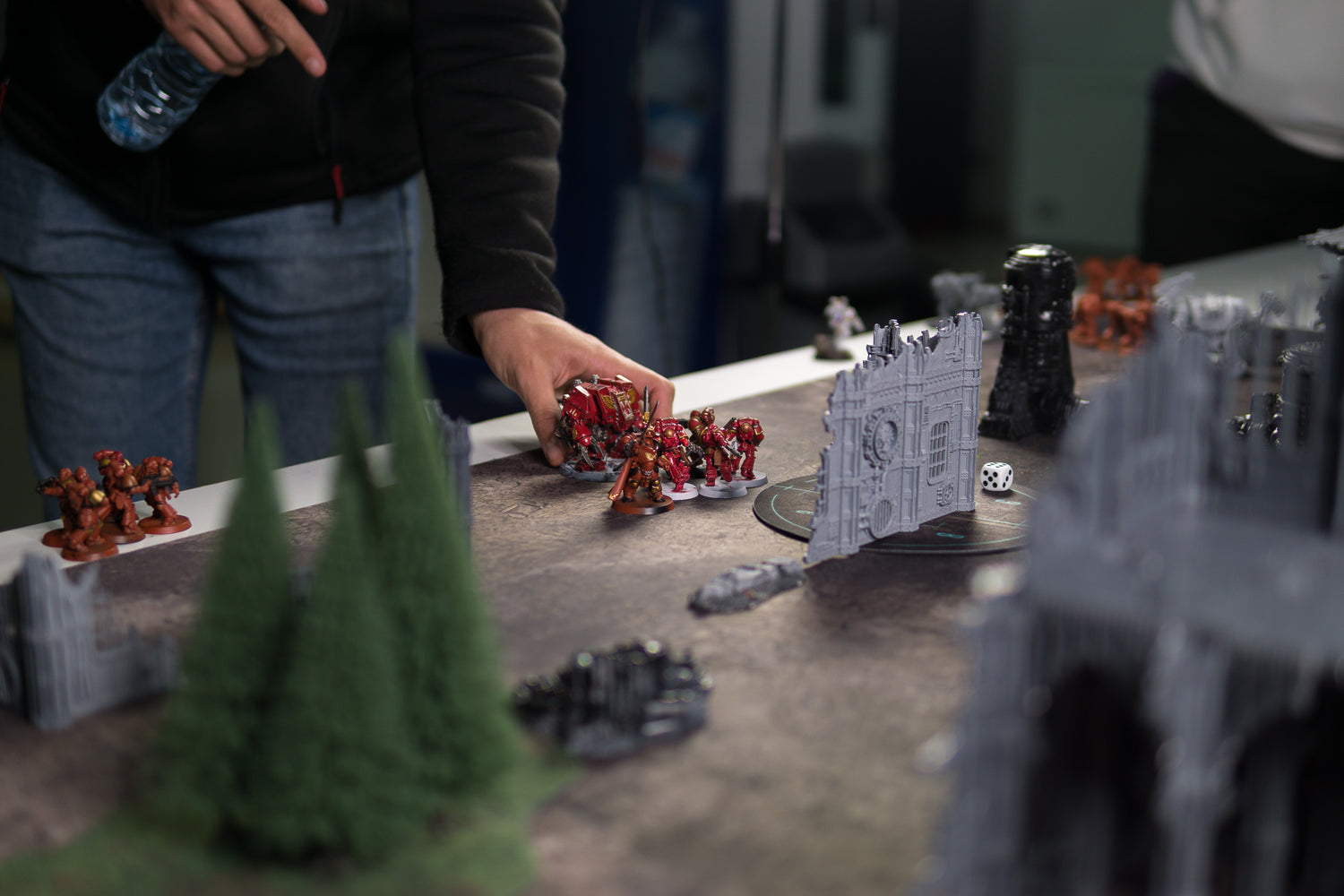 table with a set of painted miniature figurines and a dice